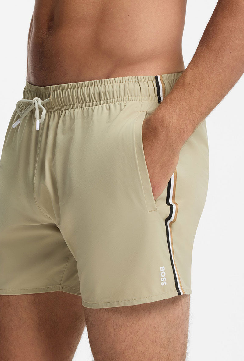 Front image of a model wearing Boss iconic swimshorts in beige, by brand Boss