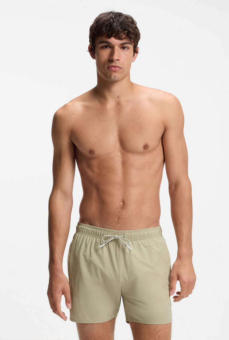 Front image of a model wearing Boss iconic swimshorts in beige, by brand Boss