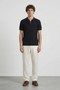 Front image of a model wearing Deep colin zip polo in black, by brand Deep