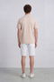 Back image of a model wearing the Deep leroy polo in peach, by brand Deep