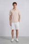 Front image of a model wearing the Deep leroy polo in peach, by brand Deep