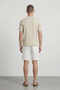 Back image of a model wearing the Deep river button knit polo in beige, by brand Deep