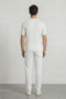 Back image of a model wearing the Deep river button knit polo in white, by brand Deep
