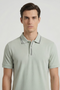 Front image of a model wearing the Deep roman button polo in light green, by brand Deep
