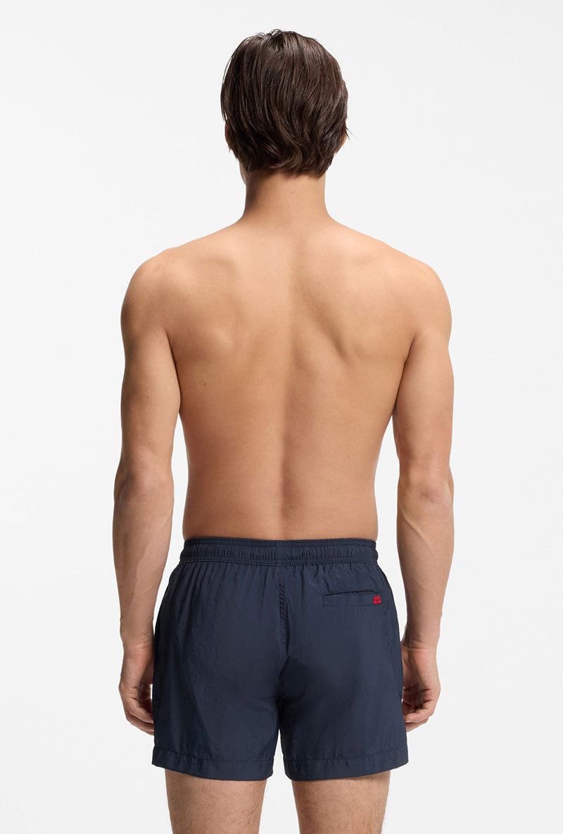 Back image of a model wearing Dominica swimshorts in navy, by brand Hugo