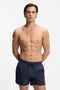 Front image of a model wearing Dominica swimshorts in navy, by brand Hugo