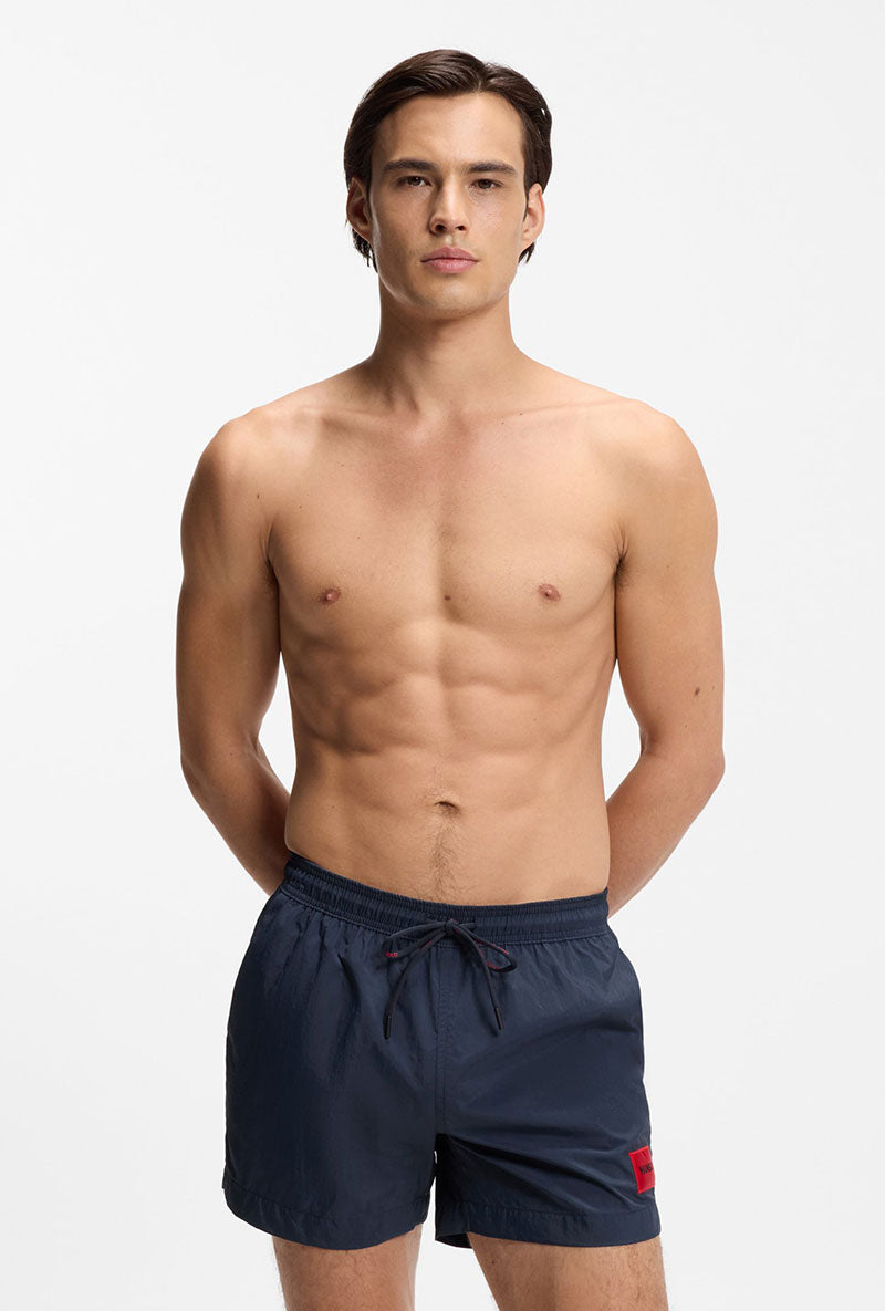 Front image of a model wearing Dominica swimshorts in navy, by brand Hugo