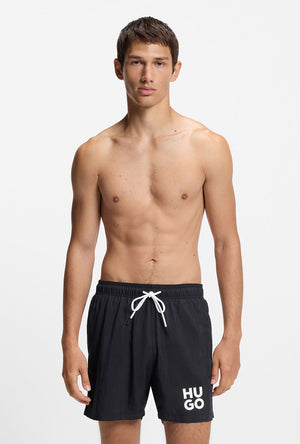 Front image of a model wearing the Paolo swimshorts in black, by brand Hugo