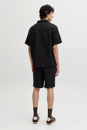 Back image of a model wearing the Jaiden wavy jogger shorts in black, by brand Jack&jones