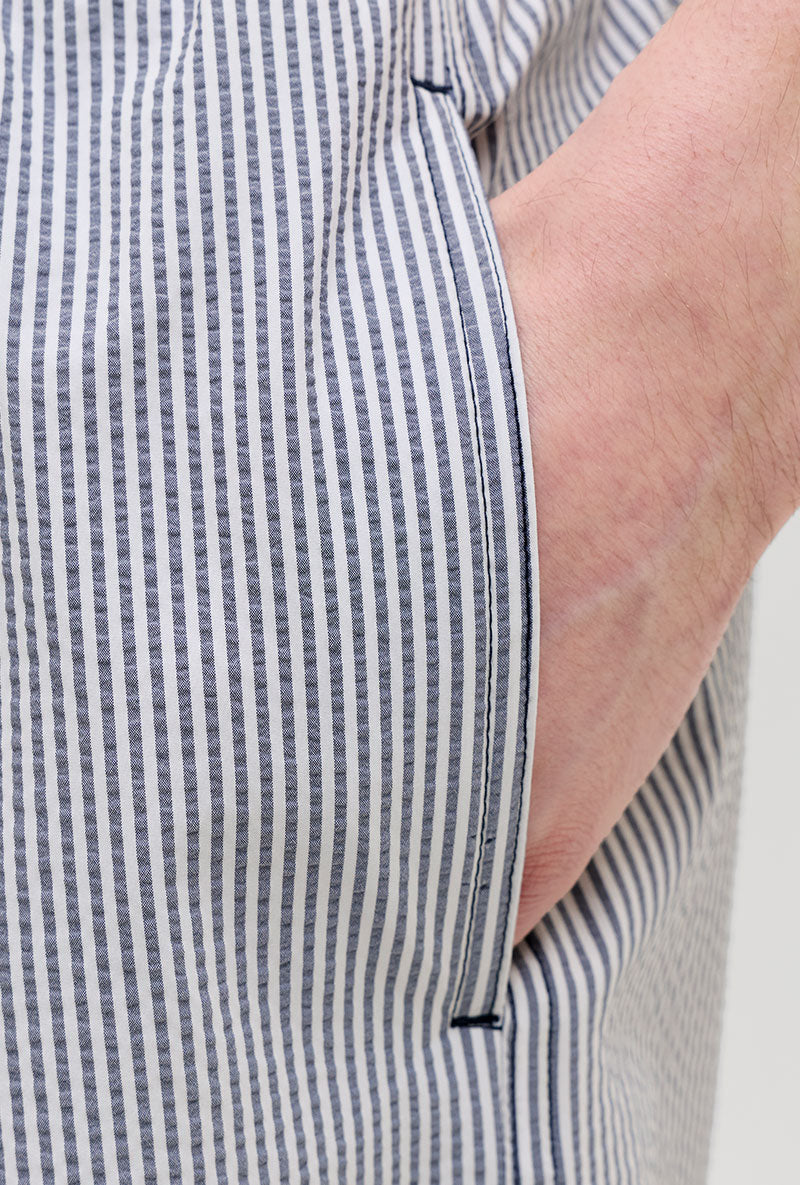 Front pocket detail image of a model wearing Maui ocean seersucker swimshorts in navy, by brand Jack&jones