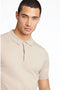 Front image of a model wearing the Ecovero s/s knit polo in sand, by brand Lindbergh