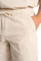 Front detail image of a model wearing the Seersucker shorts in beige, by brand Lindbergh