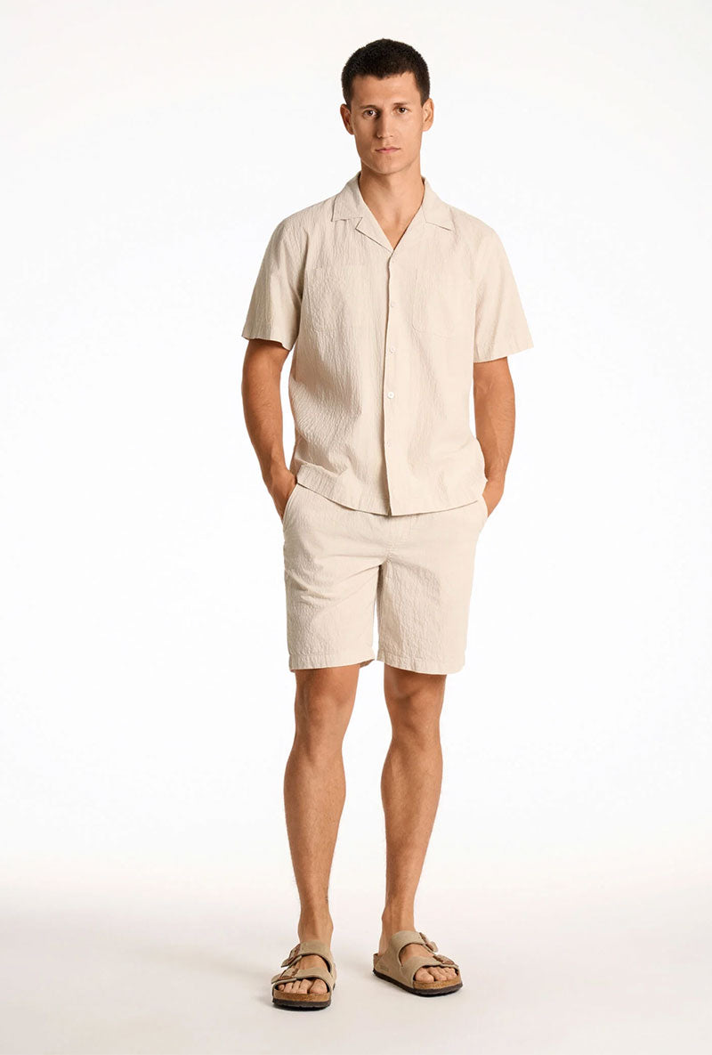 Front image of a model wearing Seersucker shorts in beige, by brand Lindbergh