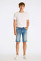 Front image of a model wearing Superflex denim shorts in dark denim, by brand Lindbergh