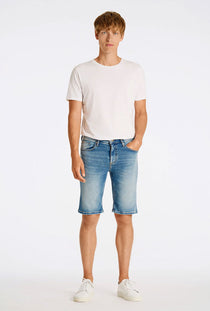 Front image of a model wearing the Superflex denim shorts in dark denim, by brand Lindbergh