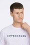 Front image of a model wearing the Lindbergh logo print ss tshirt in white, by brand Lindbergh