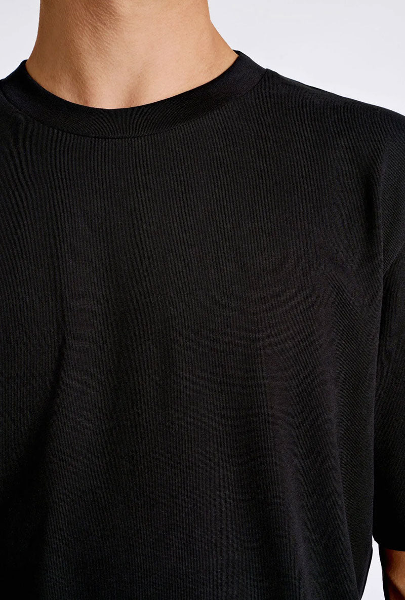 Front image of a model wearing Oneck oversize tshirt in black, by brand Lindbergh