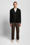 Front image of a model wearing Lyle and scott merino v neck cardigan in black, by brand Lyle and scott