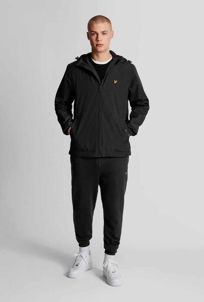 Front image of a model wearing Lyle and scott zip through hooded jacket in black, by brand Lyle and scott