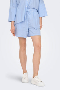 Front image of a model wearing the Augusta shorts in light blue, by brand Only