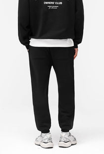 Back image of a model wearing the Owners club sweatpant in black, by brand Represent