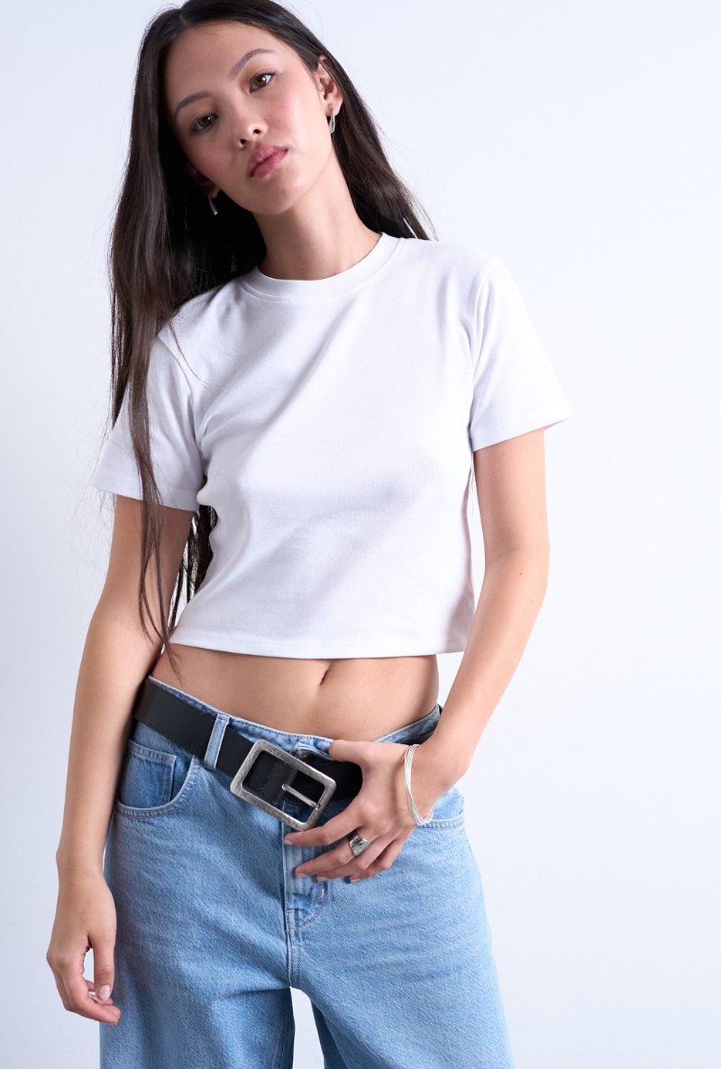 Front image of a model wearing Everyday crop top in white, by brand Top shop
