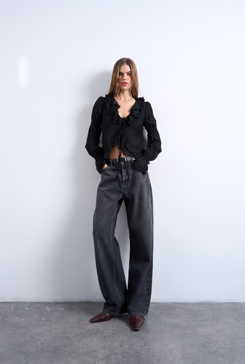Front image of a model wearing Fiona ruffle top in black, by brand Top shop