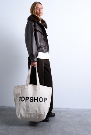 Front image of a model wearing the Ivy tote bag in white, by brand Top shop