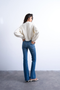 Back image of a model wearing the Jamie high rise flared jeans in denim, by brand Top shop