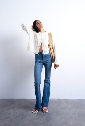 Front image of a model wearing Jamie high rise flared jeans in denim, by brand Top shop