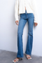 Front image of a model wearing the Jamie high rise flared jeans in denim, by brand Top shop