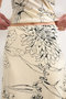 Front detail image of a model wearing the Mani asymmetric slip skirt in cream, by brand Top shop