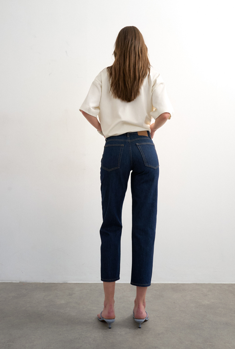 Back image of a model wearing Runway cropped jeans in dark denim, by brand Top shop