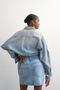 Back image of a model wearing the Silje mini denim skirt in denim, by brand Top shop