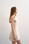 Front image of a model wearing the Zenia mini dress in ecru, by brand Top shop
