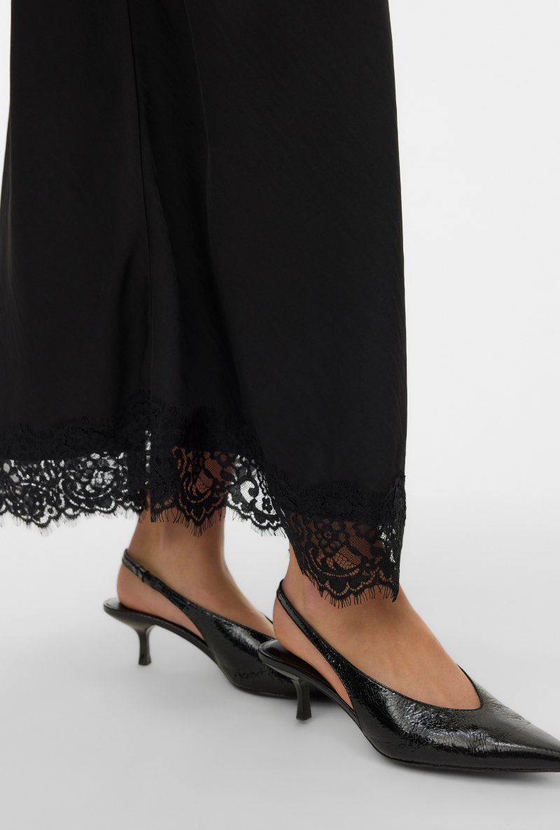 Close up image of a model wearing Vero moda julia hw lace maxi skirt in black, by brand Vero moda