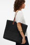 Side image of a model wearing Vero moda sisso beach bag in black, by brand Vero moda