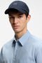 Front image of a model wearing the Derrel cap in navy, by brand Boss