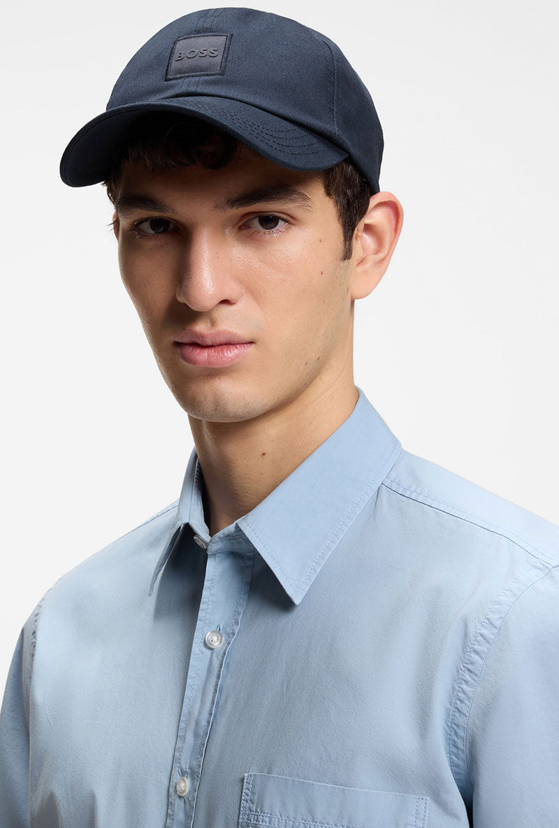 Front image of a model wearing Derrel cap in navy, by brand Boss