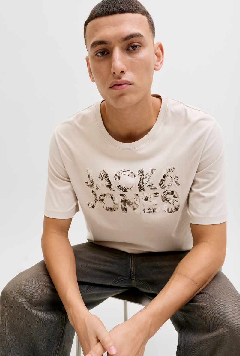Front image of a model wearing Jack and jones jeff logo tee in stone, by brand Jack&jones