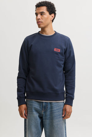Front image of a model wearing the Rush sweat crew neck sweatshirt in navy, by brand Jack&jones