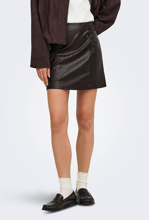 Front image of a model wearing the Ella pu mini skirt in black, by brand Jacqueline de yong