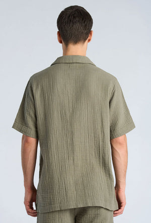 Back image of a model wearing the Cotton muslin resort shirt in sage, by brand Lindbergh