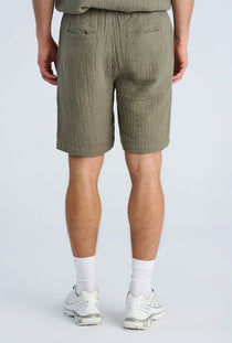 Back image of a model wearing the Cotton muslin shorts in sage, by brand Lindbergh