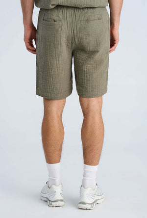Back image of a model wearing the Cotton muslin shorts in sage, by brand Lindbergh