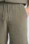 Front image of a model wearing the Cotton muslin shorts in sage, by brand Lindbergh