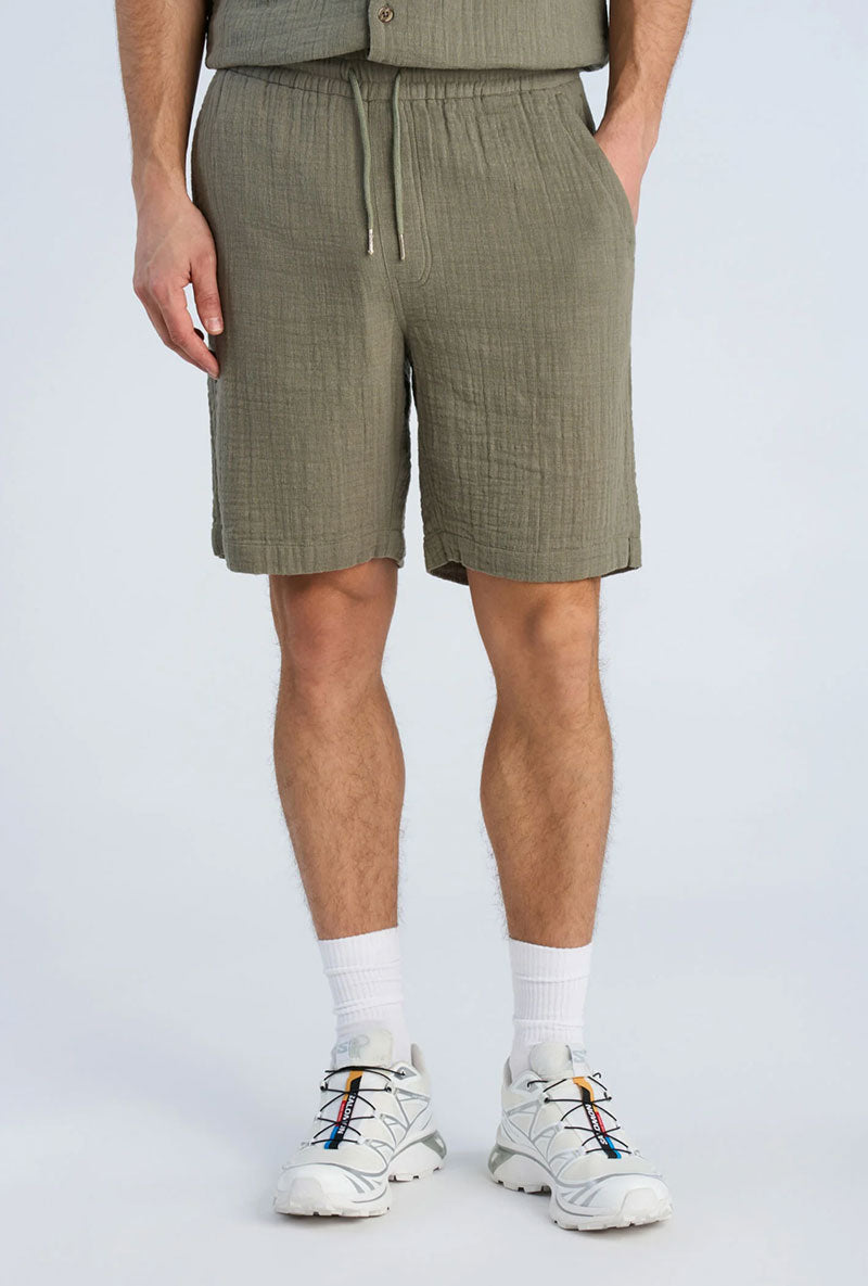 Front image of a model wearing Cotton muslin shorts in sage, by brand Lindbergh