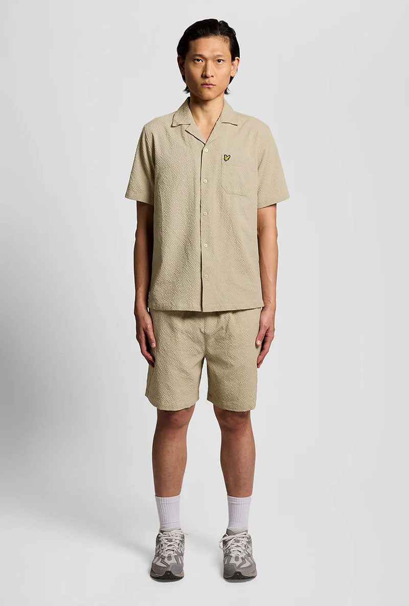 Front image of a model wearing Crinkle resort shorts in stone, by brand Lyle and scott