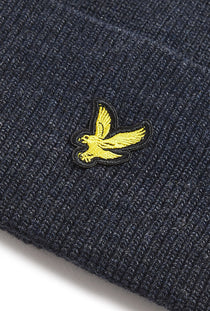 Logo detail image of the Lyle and scott lambswool ribbed beanie in navy, by brand Lyle and scott