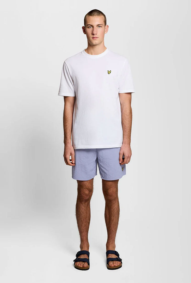 Front image of a model wearing Plain swimshorts in blue, by brand Lyle and scott